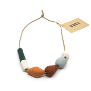 Assorted coloured chunky clay beads on tan suede cord.