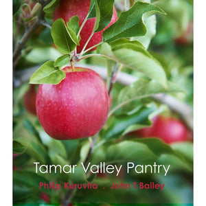 A photograph of a red apple, surrounded by greens leaves.