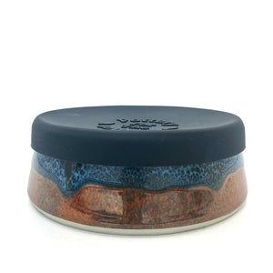 Deep blue and red rust ceramic bowl with a black silicone lid.
