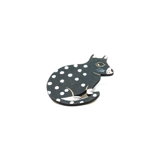 Handcrafted wooden quoll brooch painted black with white spots.