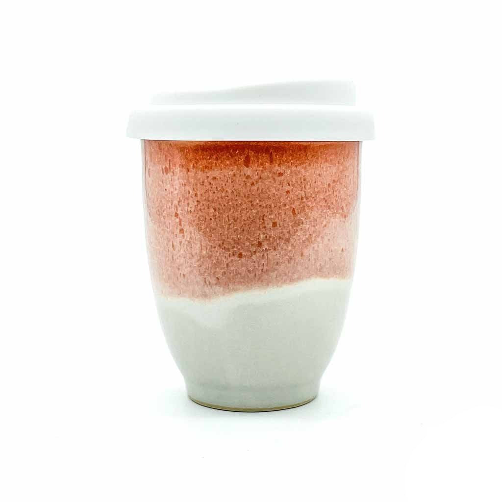 Light orange and cream with a white silicone lid ceramic cup.