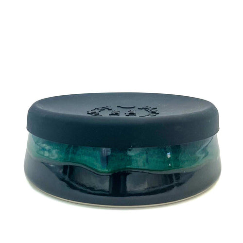 Dark blue and green ceramic green pottery bowl with black silicone lid.