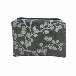 A material purse with a white plant and light grey background.