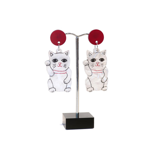 White lucky cats with red disc stud earrings.