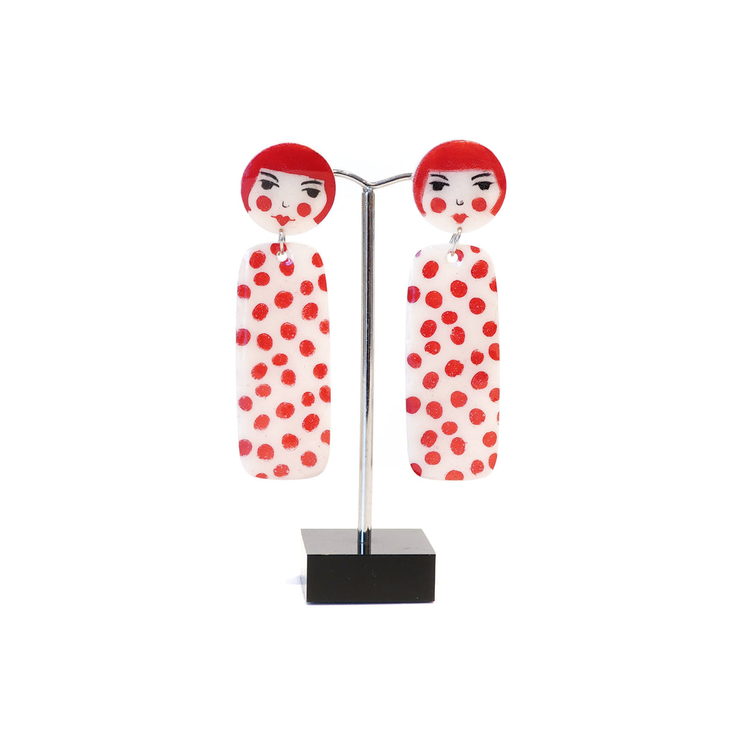 White acrylic with red spots dangle earrings.