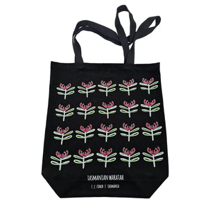A black cotton tote with Tasmanian waratah pictured on the front.